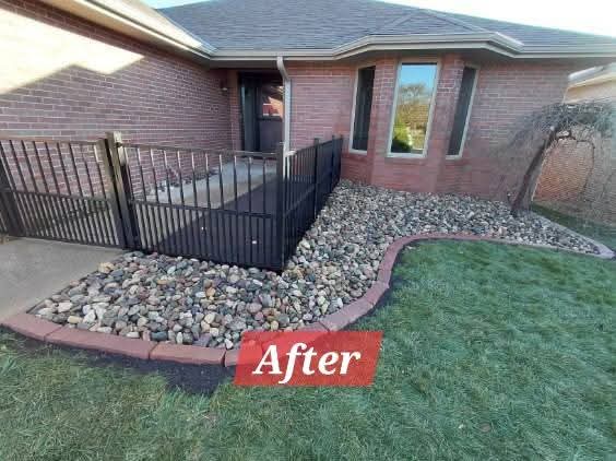 After: the same front yard with a clean rock bed and brick edging