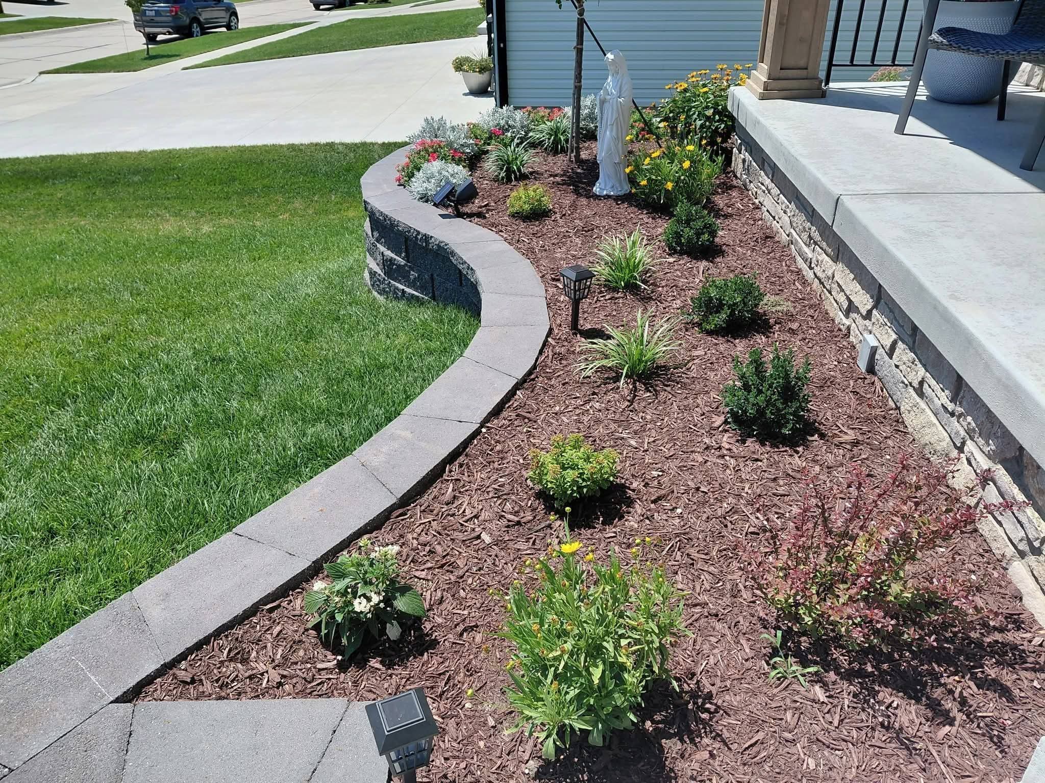 A curved block wall around a planted flower bed