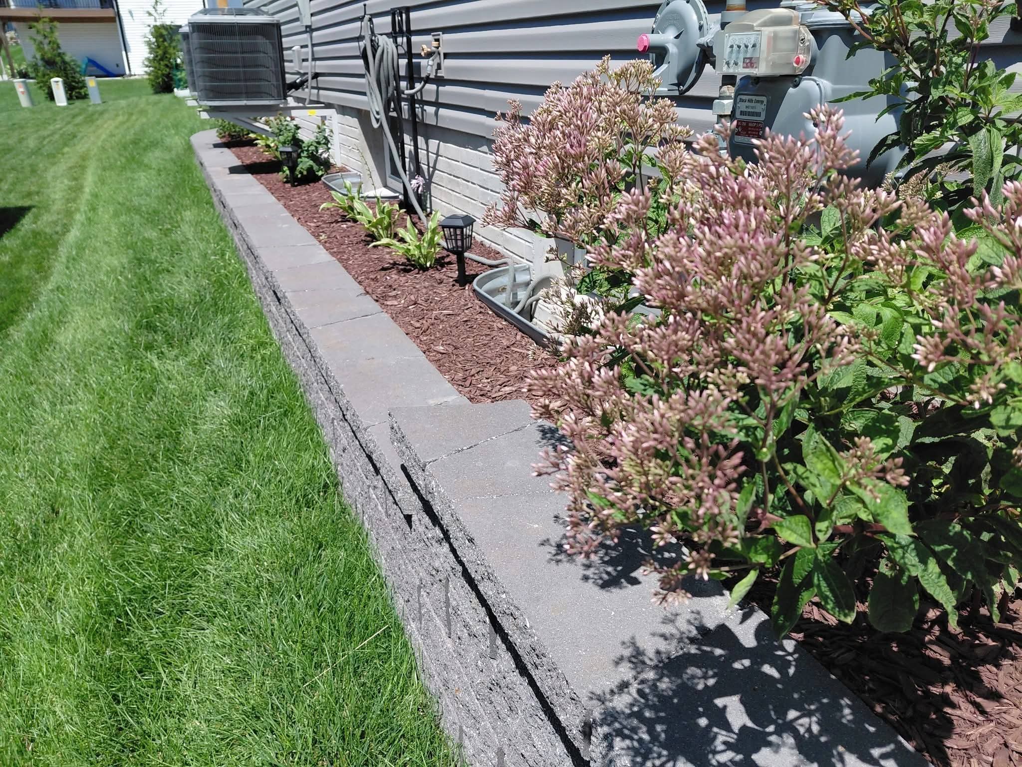 A block wall with a planted flower border